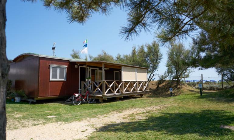 Holzhaus mit Fahnen, nahe am Strand.