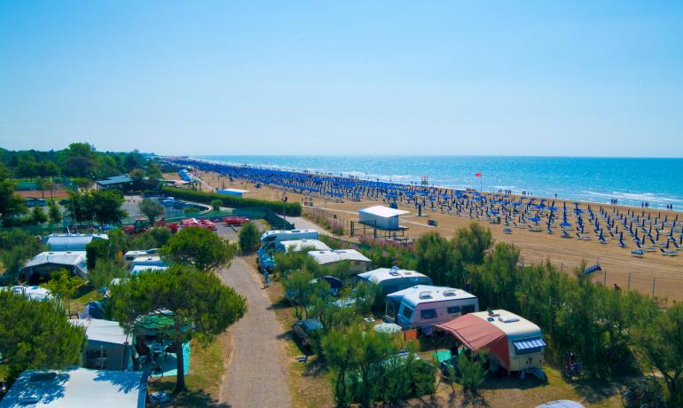 Beach with umbrellas and campsite near the sea.